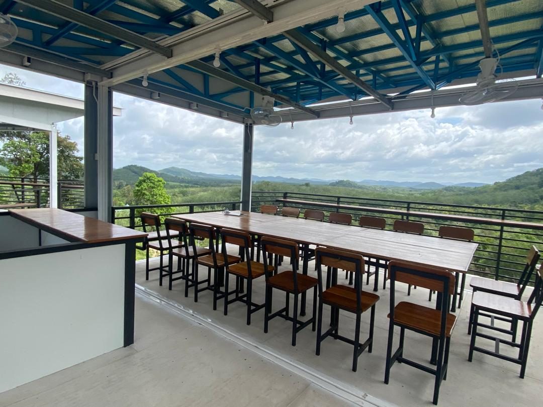 Skydeck Restaurant terbuka dengan meja kayu panjang dan pemandangan gunung